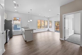 A spacious kitchen with a refrigerator, sink, and cabinets.